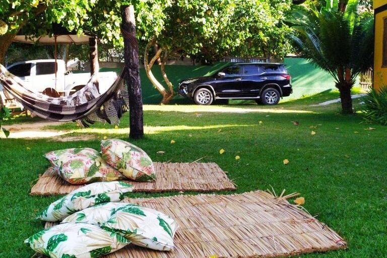 Jardim com tapetes e almofadas na Pousada Mangue Seco